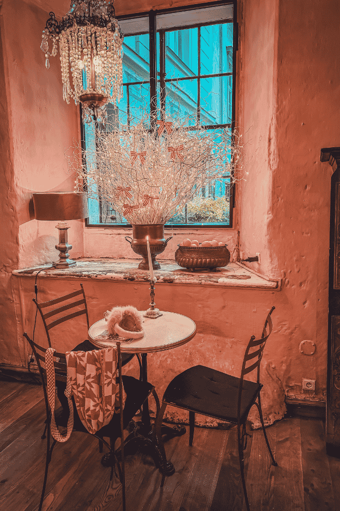 A cozy antique-filled table by the window inside Café Camelot in Krakow, Poland.
