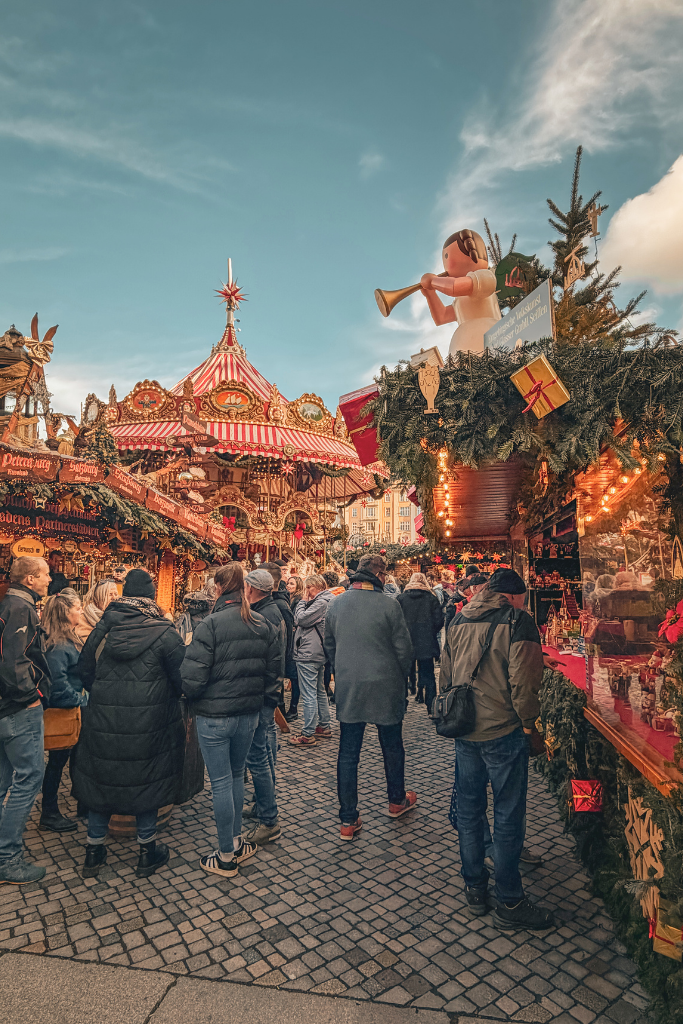 The festive heart of Dresden’s Striezelmarkt, where elaborately decorated wooden stalls, twinkling lights, and a traditional carousel fill the historic square with Christmas magic.