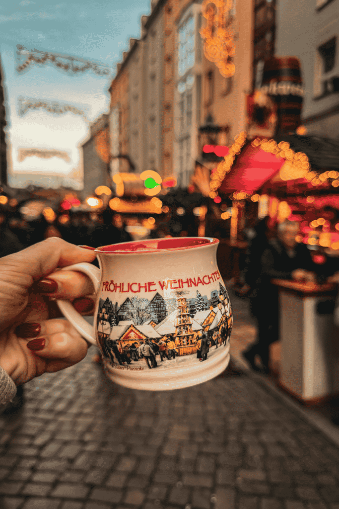 Warm up at Dresden’s Christmas markets with a mug of Glühwein, served in a festive keepsake cup amid glowing wooden stalls and twinkling holiday lights.