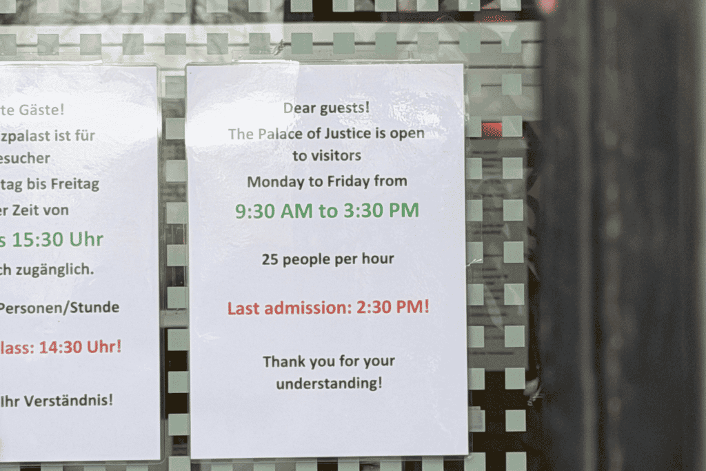 A sign at Vienna’s Palace of Justice lists visitor hours from Monday to Friday, 9:30 AM to 3:30 PM, with last admission at 2:30 PM.