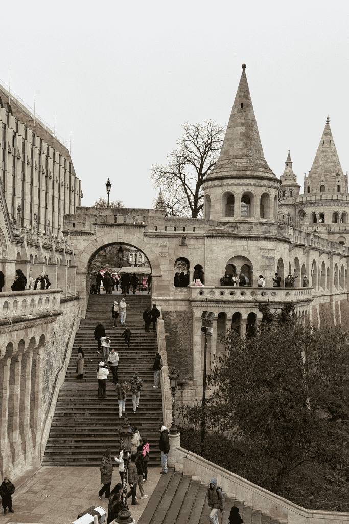 Stone towers, arches, and stairways at Fisherman’s Bastion in Budapest, with visitors walking through the historic site.