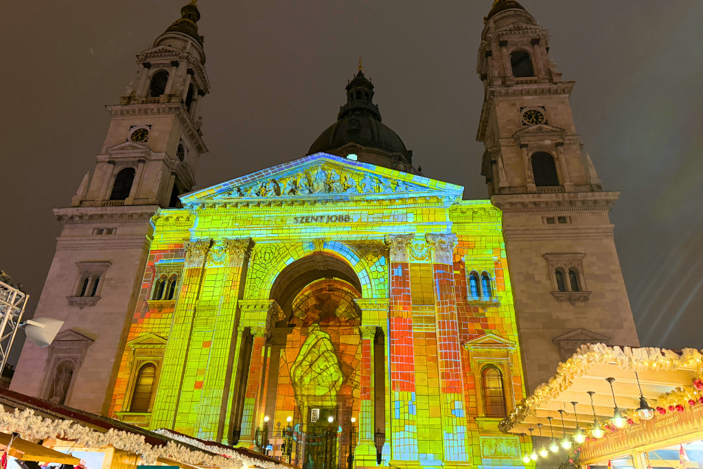 Colorful lights are projected across the front of St. Stephen’s Basilica during the Budapest Christmas market.