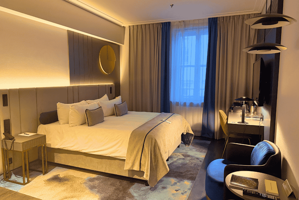 A modern guest room with a large bed and cozy lighting at Garamond, a Tribute Portfolio Hotel in Krakow.