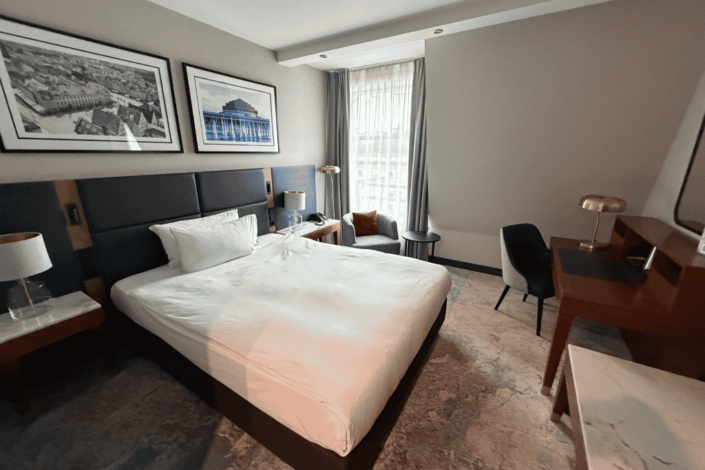 Guest room at the Wyndham Hotel Wroclaw Old Town with a large bed, desk, and sitting area.