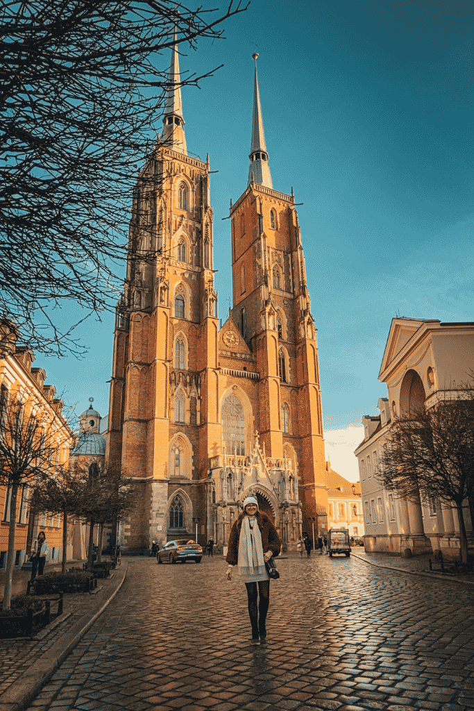 Kate standing in front of the towering Gothic Cathedral of St. John the Baptist on Cathedral Island in Wroclaw, Poland.