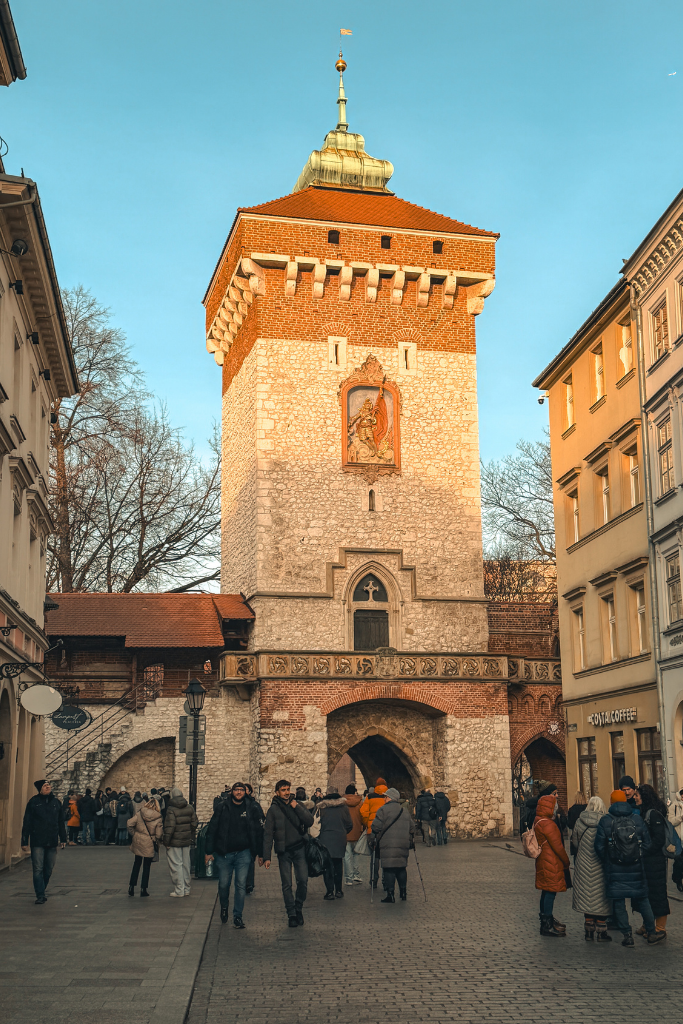 St. Florian’s Gate in Krakow, Poland, with visitors walking through the historic medieval entrance to Old Town.