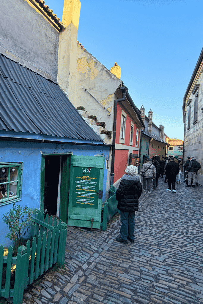 Wandering the colorful cobblestone lane of Golden Lane inside Prague Castle, lined with tiny historic houses that once housed castle workers and artisans.