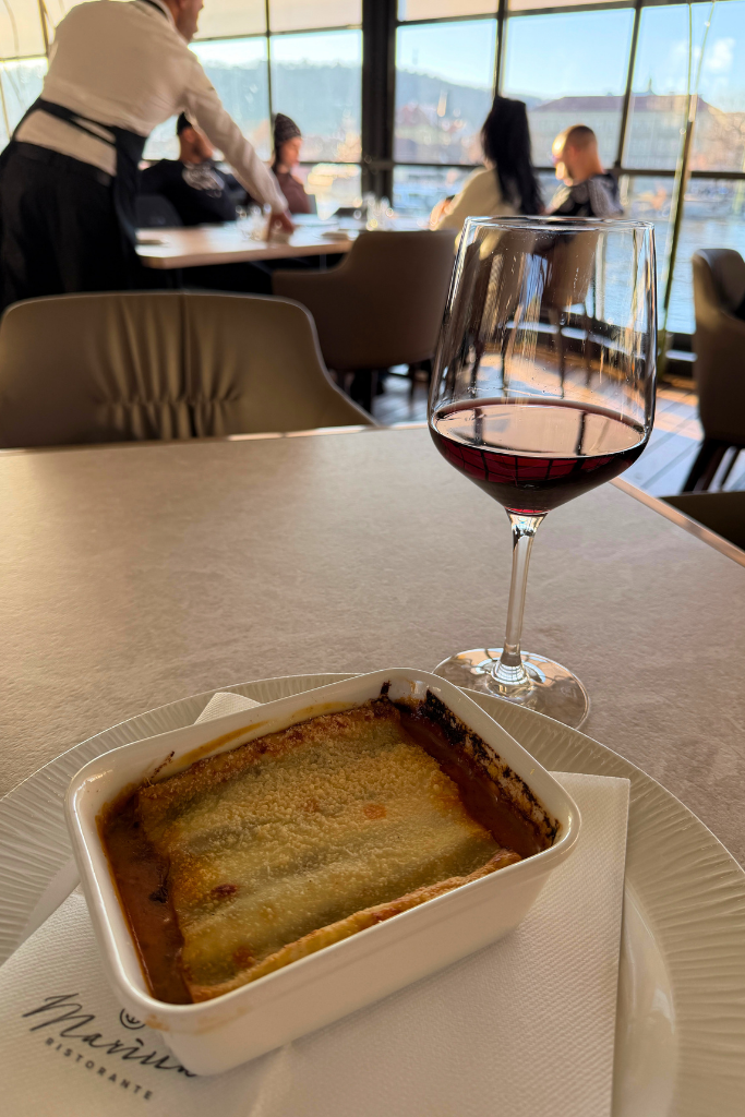A cozy meal with a glass of red wine and beautiful views across Prague’s Vltava River.