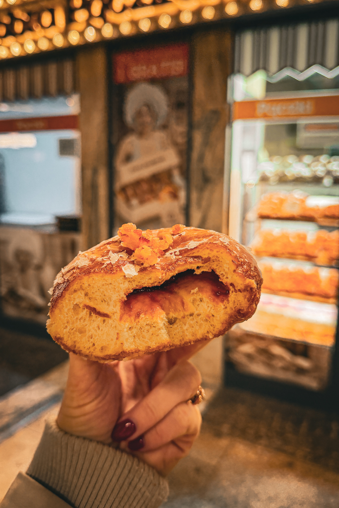 Traditional Polish pączek filled with rose jam and topped with candied orange peel in Krakow.
