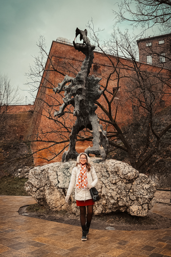 Kate standing in front of the Wawel Dragon statue near Wawel Castle in Krakow.