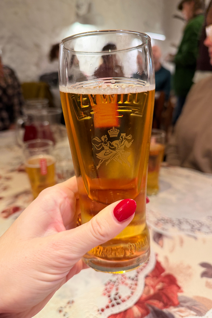 Glass of Polish beer being enjoyed during a food tour in Krakow.