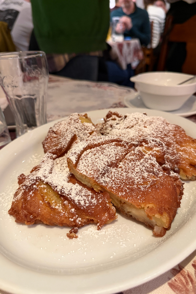 Polish apple fritters dusted with powdered sugar during a Krakow food tour.