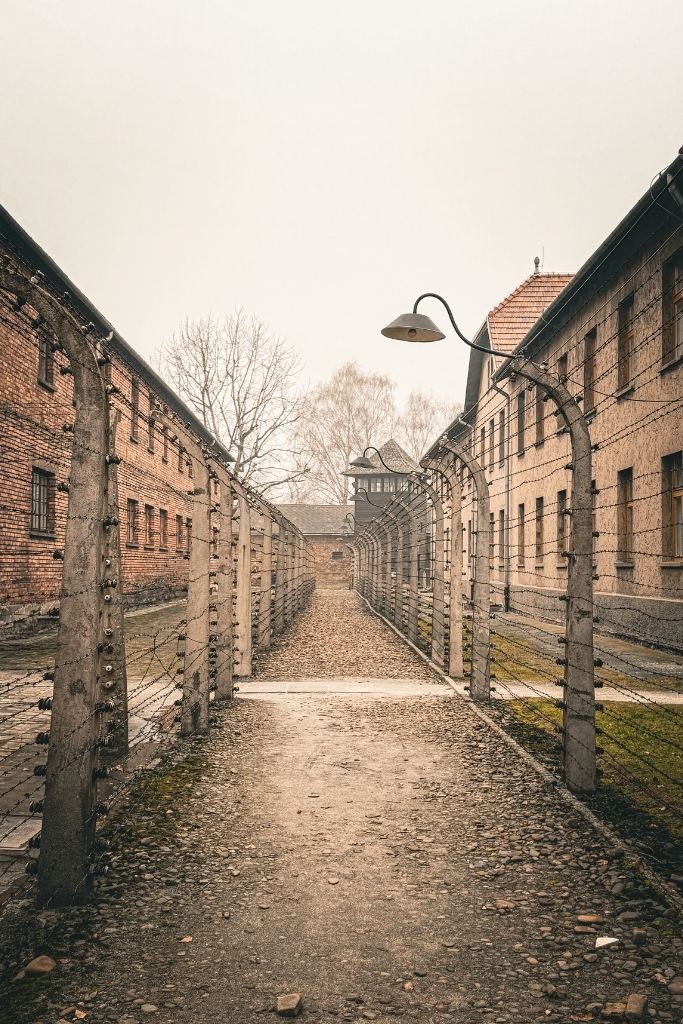 Barbed-wire fences and brick prisoner barracks at Auschwitz-Birkenau concentration camp in Poland.
