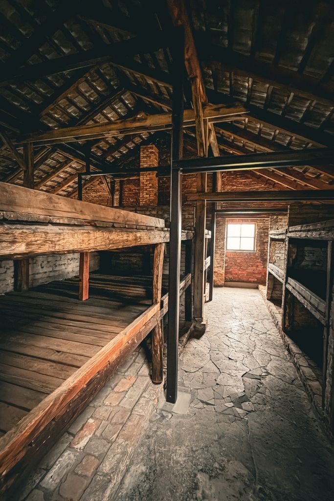 Wooden prisoner bunks inside a preserved barracks at Auschwitz II-Birkenau Memorial in Poland