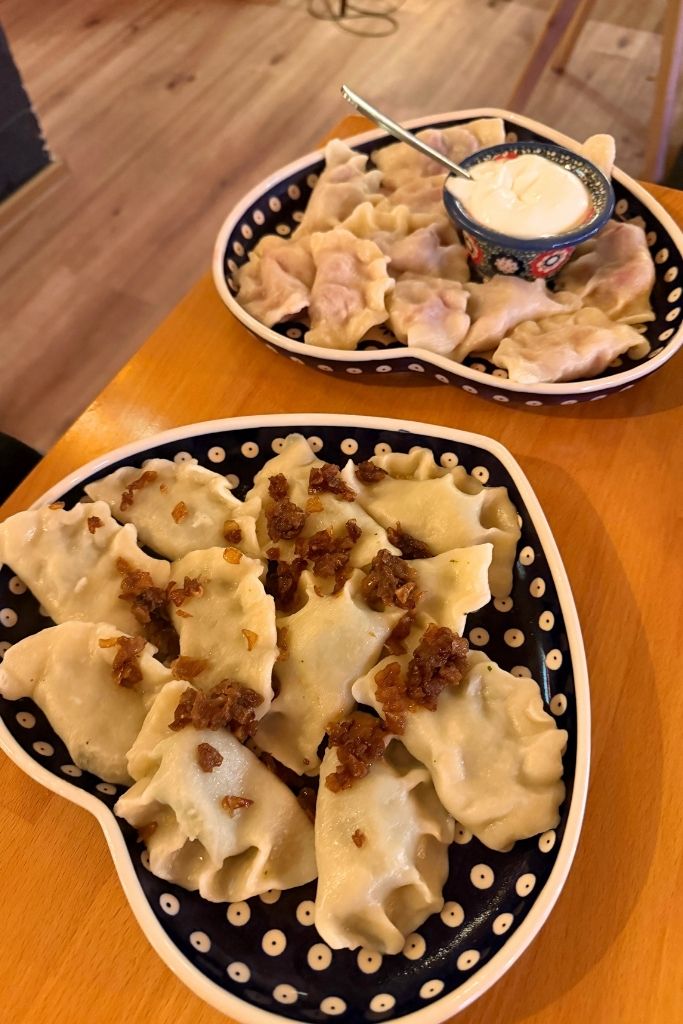 Traditional Polish pierogi topped with fried onions and served with sour cream in Krakow.