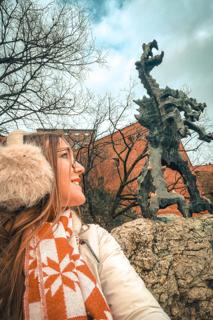 Kate posing beside the famous Wawel Dragon statue near Wawel Castle in Krakow.