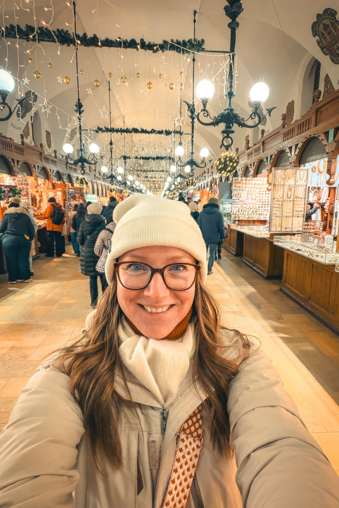 Kate visiting Krakow’s Cloth Hall decorated with Christmas lights and holiday market stalls.