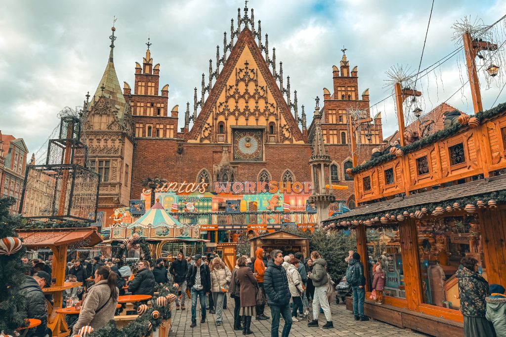 Wroclaw Christmas Market with festive wooden stalls and Santa’s Workshop in front of the historic Old Town Hall.