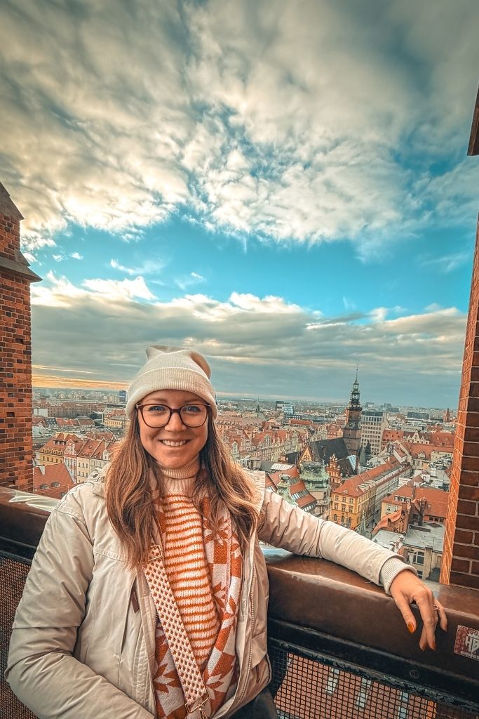 Kate overlooking Wroclaw Old Town from the Bridge of Penitents, with colorful rooftops and historic buildings in the background.