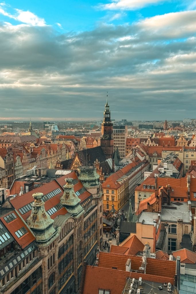 Panoramic view of Wroclaw Old Town from the Bridge of Penitents, with red rooftops and the historic Town Hall tower.