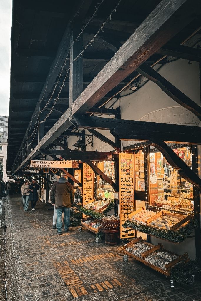 Historic Stare Jatki alley in Wroclaw lined with small artisan shops and galleries beneath wooden covered walkways.