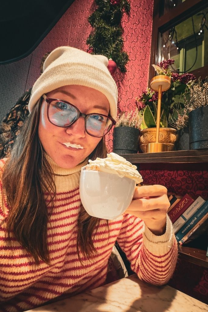 Kate enjoying a whipped cream-topped hot chocolate inside Czekoladziarnia in Wroclaw, Poland.