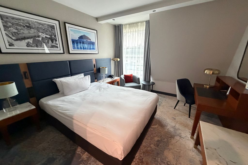 Guest room with large bed, desk, and seating area at Wyndham Wroclaw Old Town hotel.