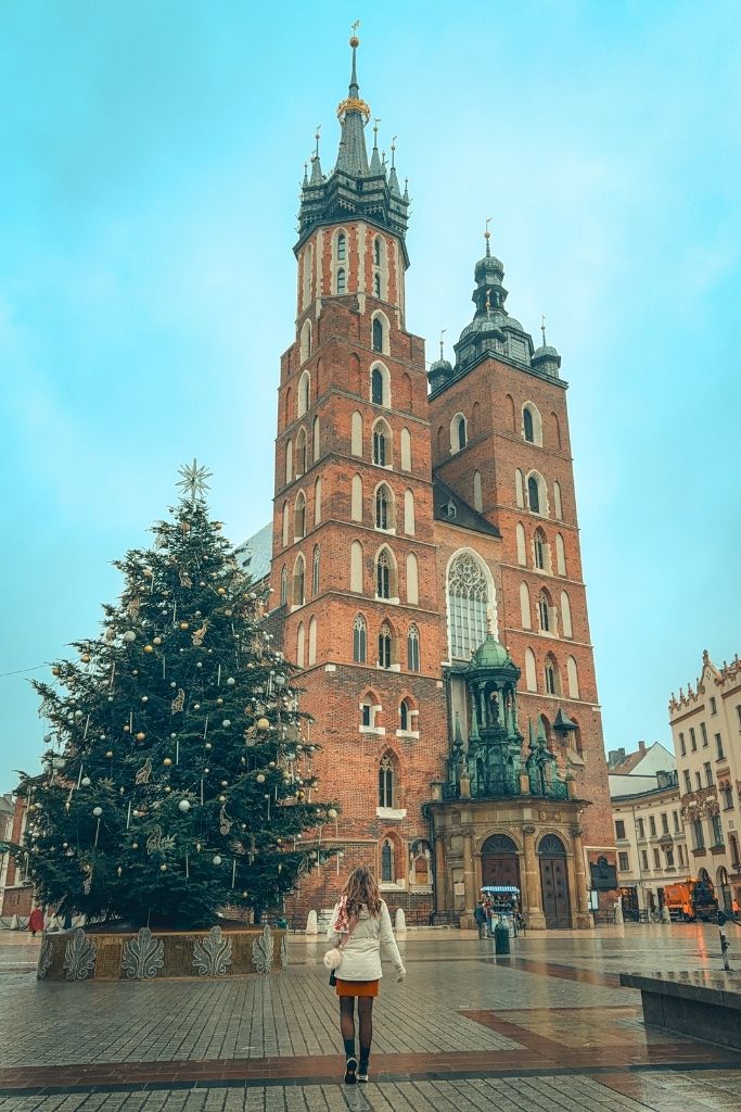St. Mary’s Basilica and a decorated Christmas tree in Krakow’s Main Market Square during winter.
