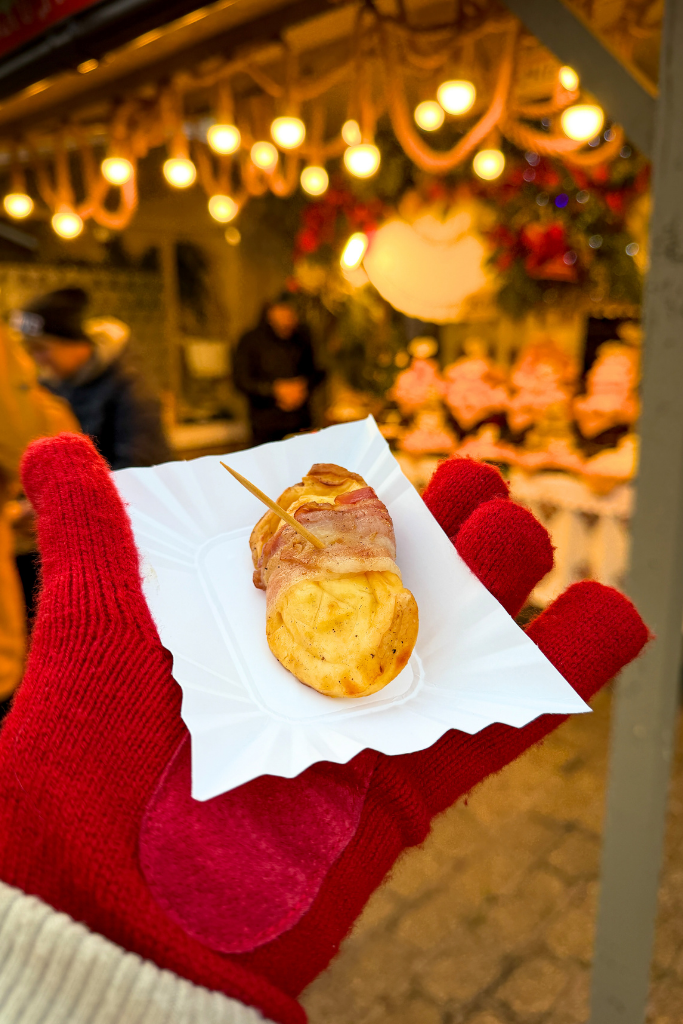 Bacon-wrapped grilled cheese served at a festive Krakow Christmas Market food stall.